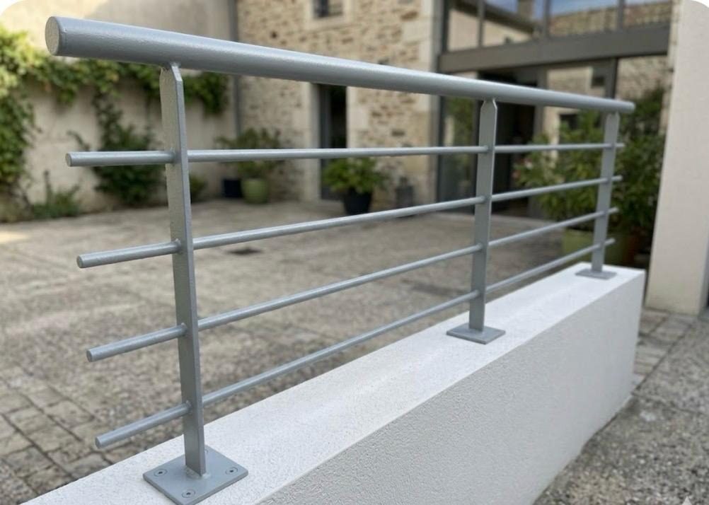Garde-corps en acier peint et verre, bordant un balcon en bois.