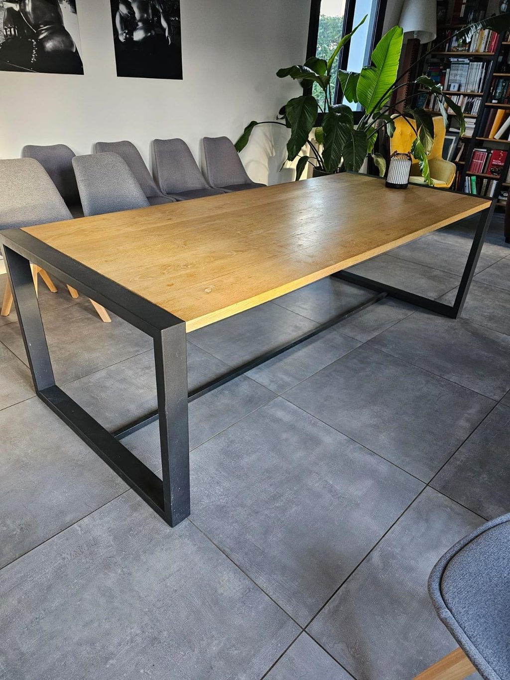 Table de salle à manger à piètement d’acier noir et plateau de bois, dans un séjour.